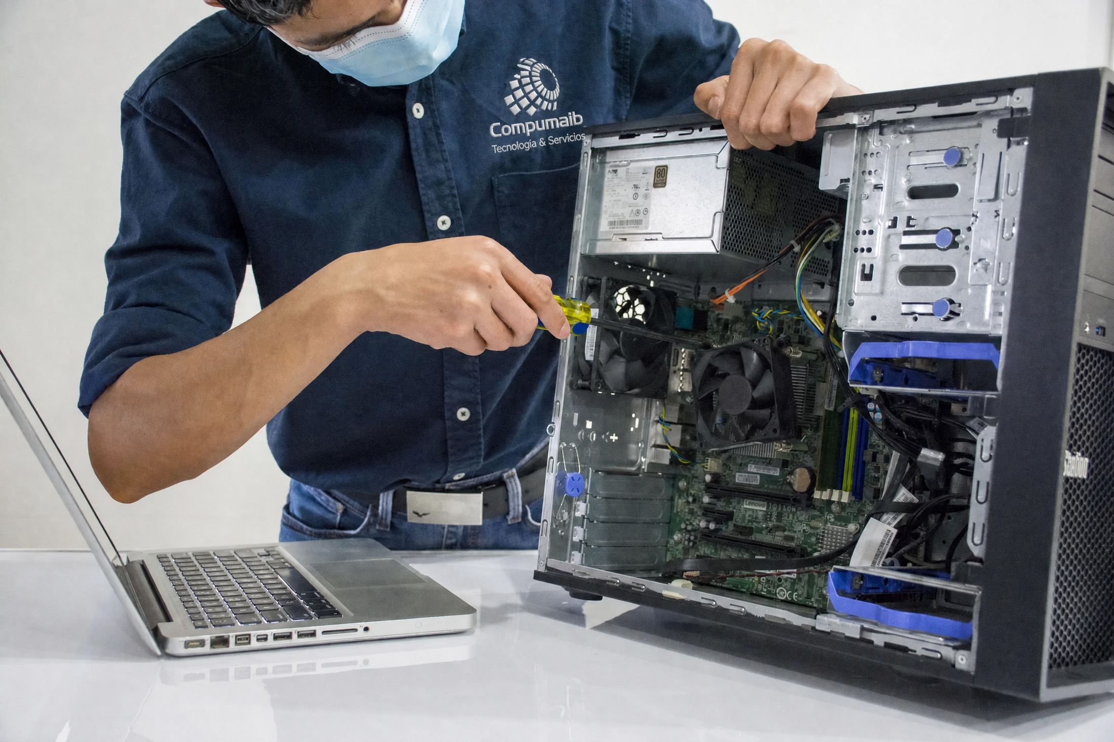 Técnico de Compumaib reparando el interior de una torre de escritorio